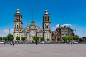 View of the Metropolitan Cathedral in Mexico City's historic center with a lively public square.